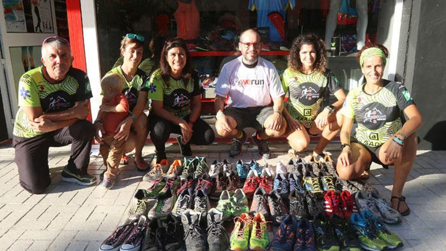 Varios de los responsables de esta iniciativa junto a las zapatillas recogidas en Málaga capital.