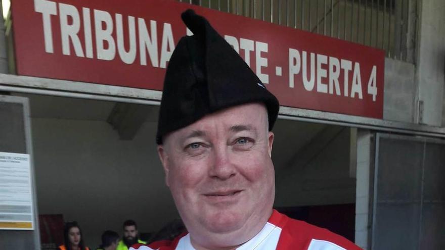 Dean March, con la camiseta del Sporting y una montera picona, ante una de las puertas de El Molinón.