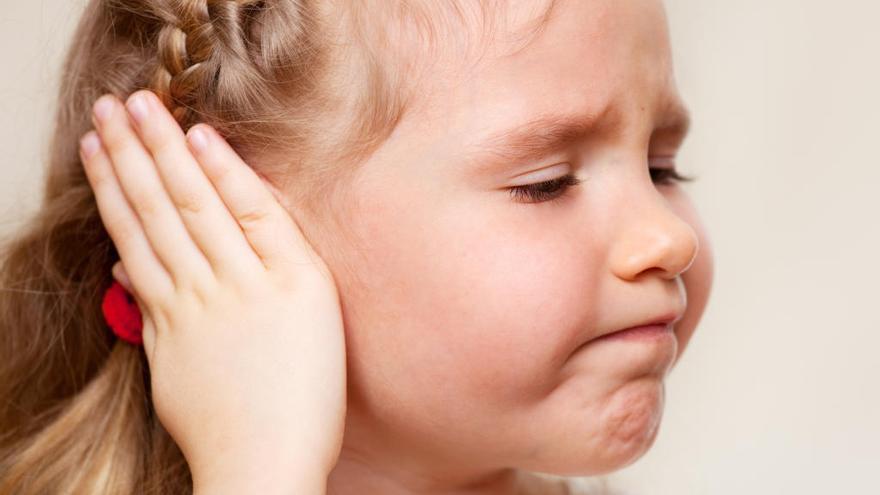 Una niña se queja de dolor de oídos.