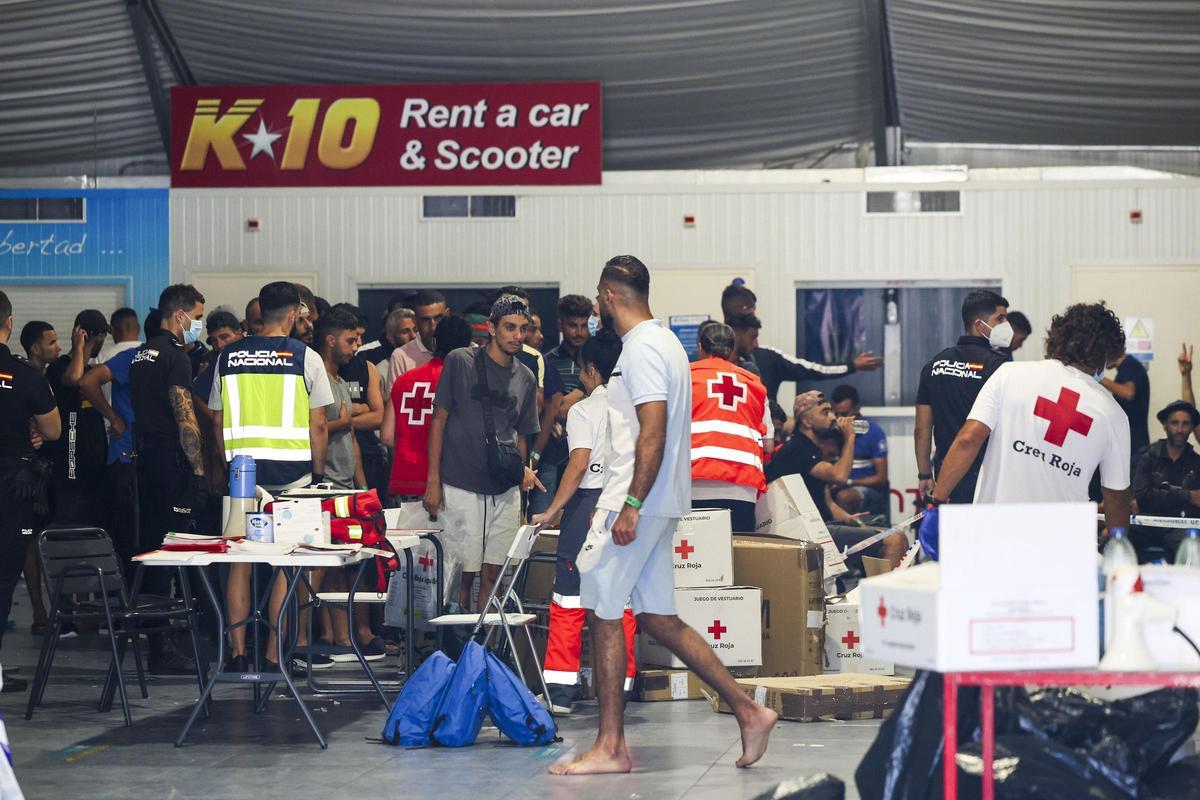 Policías y miembros de la Cruz Roja atienden a inmigrantes llegados a Ibiza.