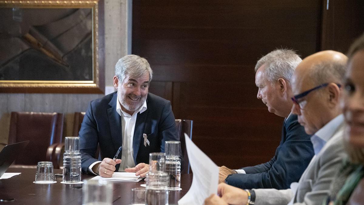 El presidente Fernando Clavijo (i) sonríe al portavoz socialista, Sebastián Franquis (c) en una anterior reunión con los grupos parlamentarios.