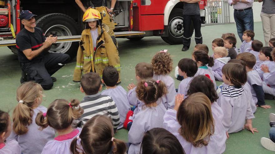 Un grupo de niños, con los bomberos.