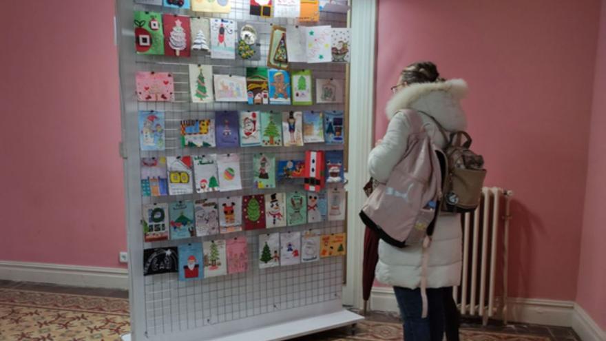 Una mujer observando postales participantes. | E. P.