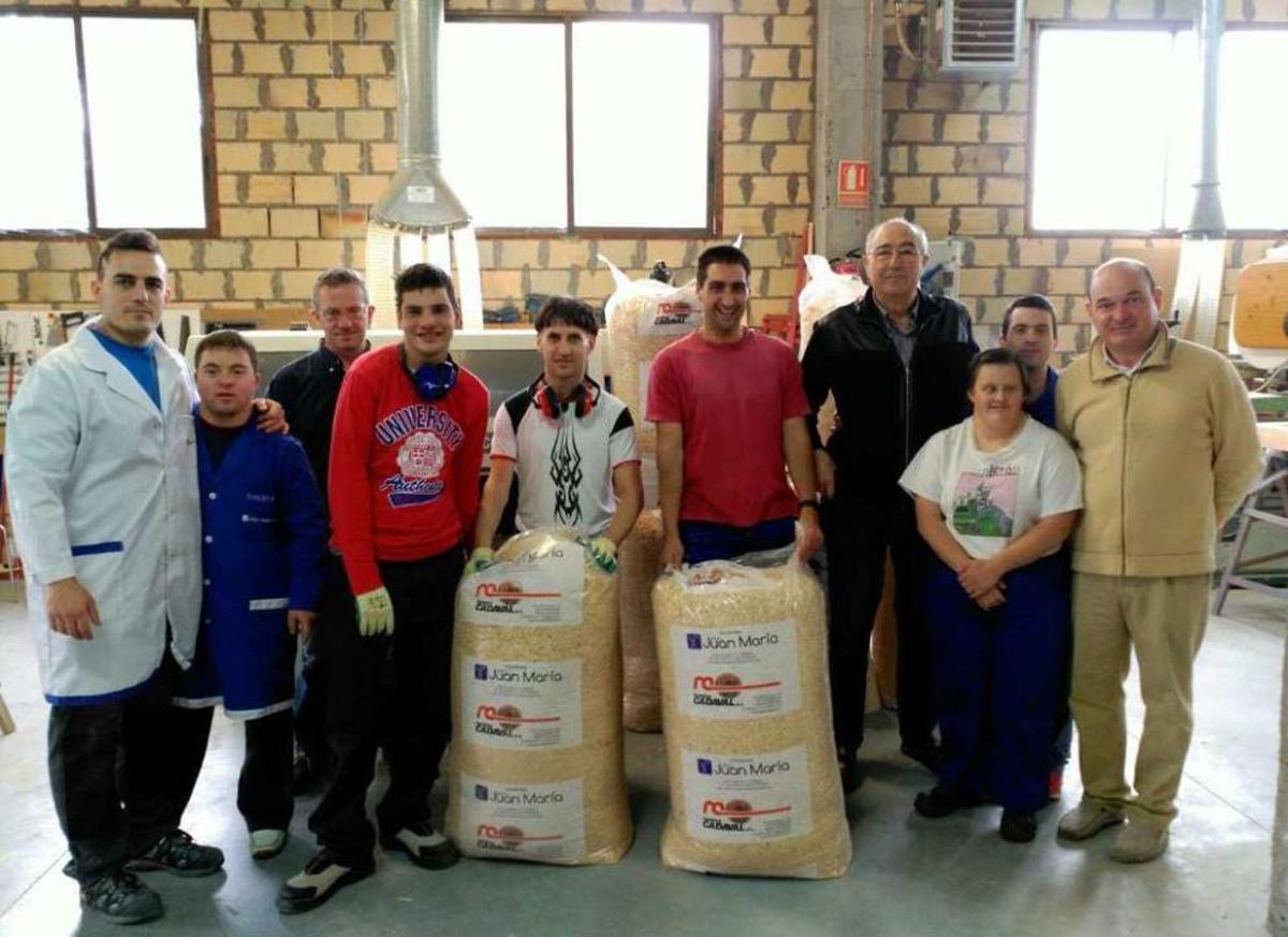 Trabajadores del taller de carpintería del Juan María muestran los sacos con su monitor, Pedro Burgo; el presidente de La Esperanza del Valle Miñor, José Santoro, y Raúl Pedreira, de Maderas Cadaval.