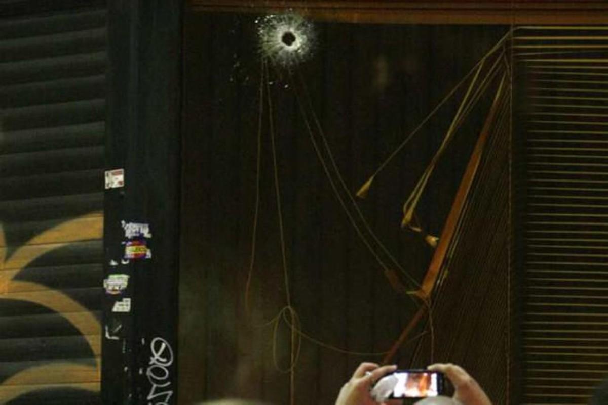 El agujero de un balazo en el cristal de un establecimiento tras el tiroteo