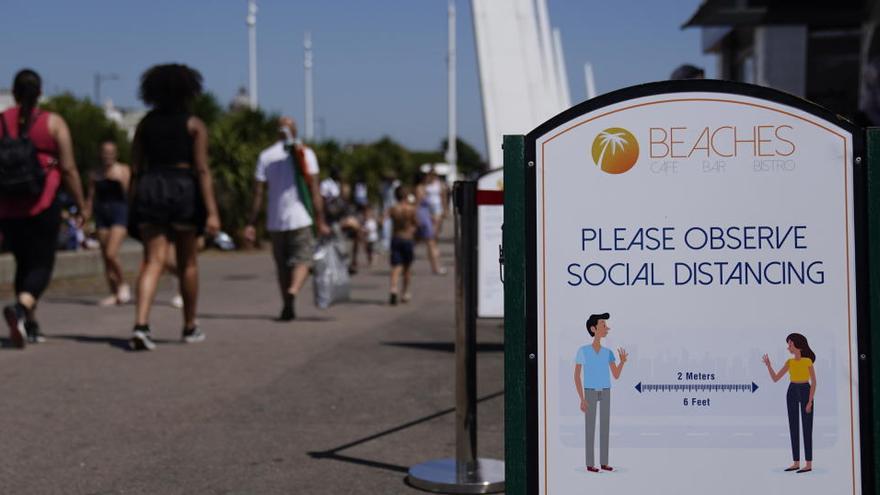 Un cartel recuerda que se debe mantener la distancia en la playa.