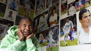 Mbappé de niño y rodeado de fotos de Cristiano Ronaldo en el Real Madrid.
