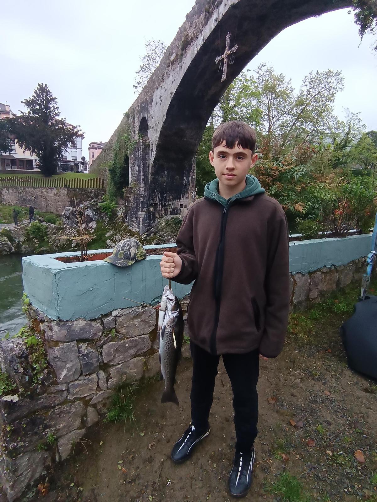 El cangués Simón Álvarez Suárez, de 14 años de edad, que pesco este domingo tres truchas en el lance de El Puente Romano.