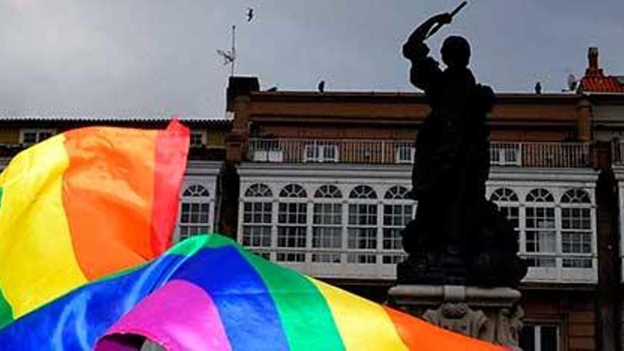 Una persona ondea una bandera Lgtbi en la plaza de María Pita de A Coruña.