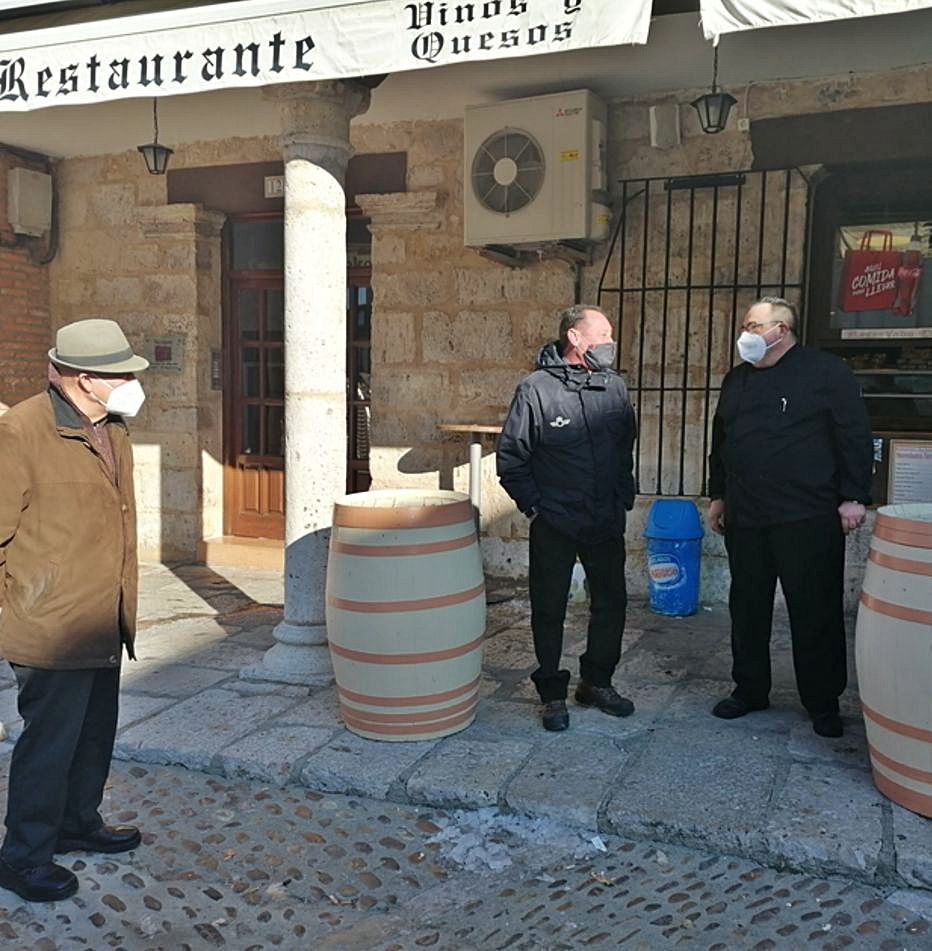 Álvaro Martín (derecha) saluda a dos clientes en su terraza. | M. J. C.