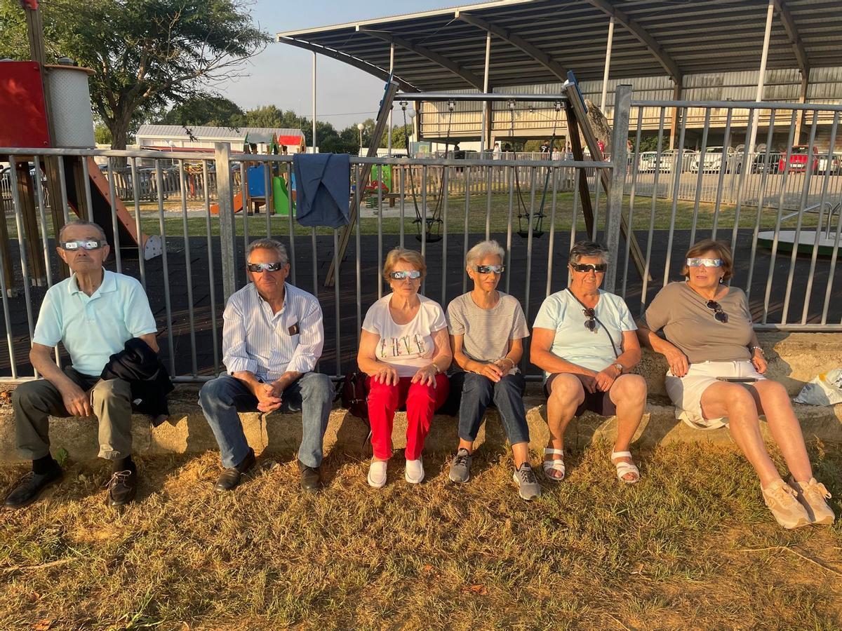 Vecinos de Abegondo esperan el eclipse sentados en el campo da feira de San Marcos.
