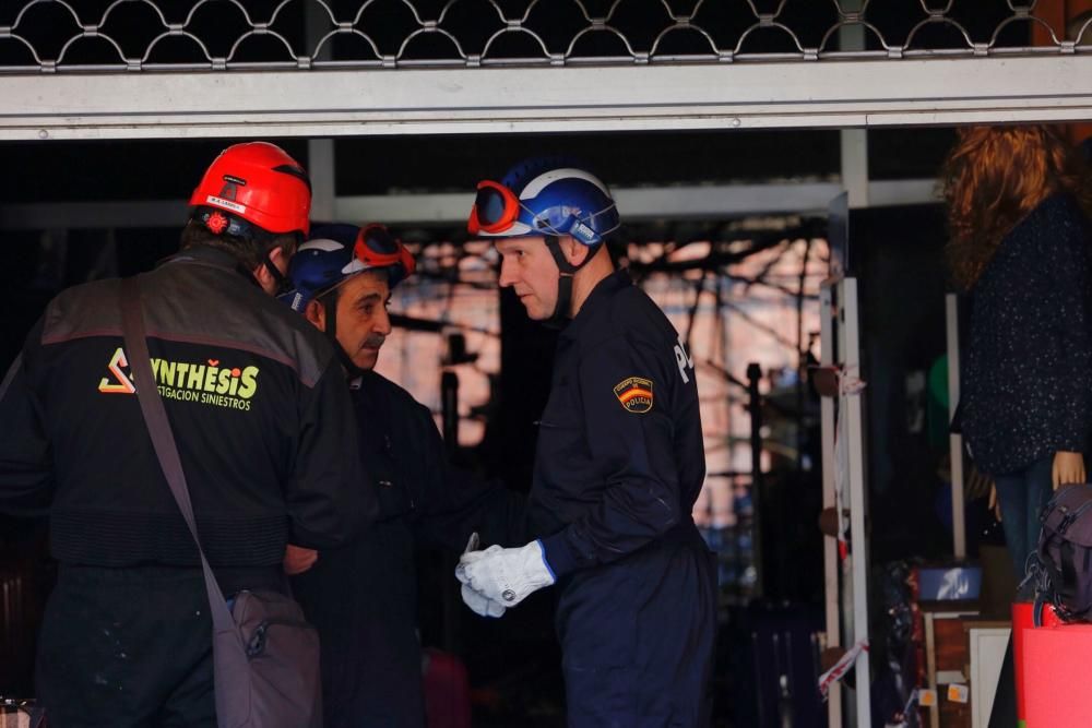 Policía científica y bomberos de Oviedo participan en la investigación que trata de esclarecer las causas del incendio de Pumarín.