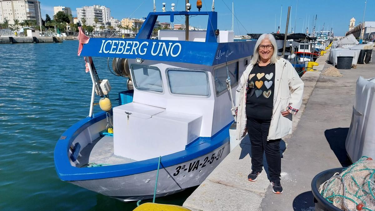 Mari Carmen Argudo, junto a la barca en la que trabaja, amarrada en el muelle pesquero de Gandia.