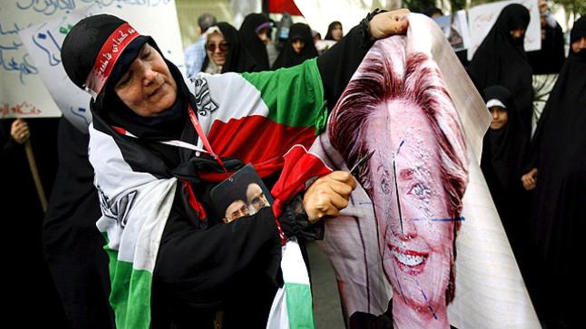Tot el món àrab ha sortit en defensa dels cooperants i de la causa palestina. A l’Iran hi va haver grans manifestacions, a la imatge, una dona talla una pancarta amb la cara de Hillary Clinton.