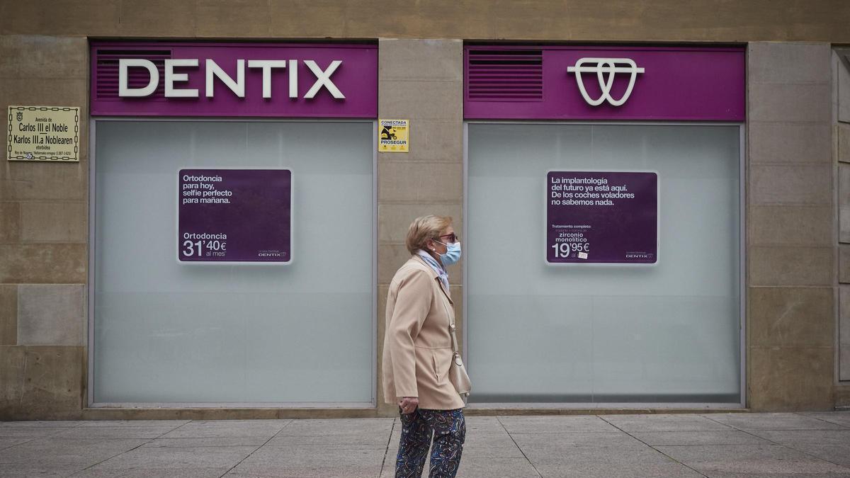 Una mujer pasea frente a una clínica de Dentix.