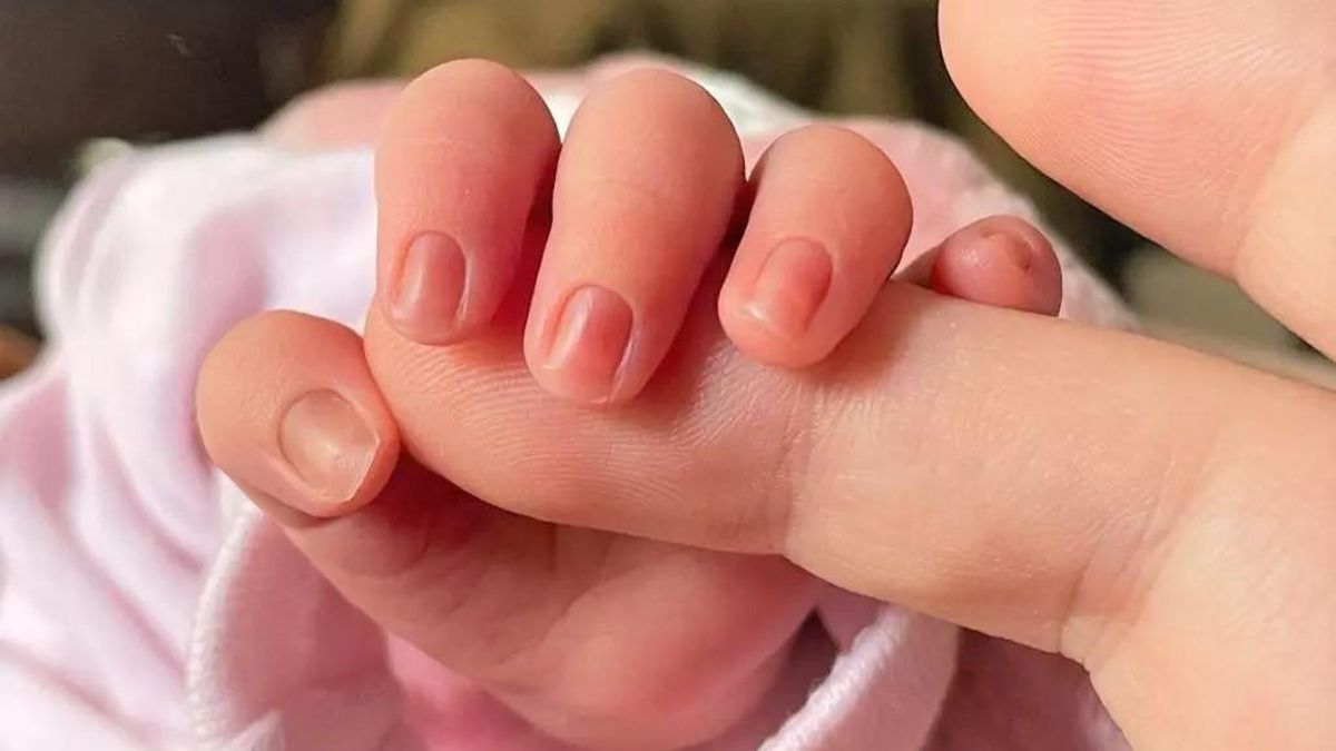 Archivo - Un bebé coge el dedo de su madre.