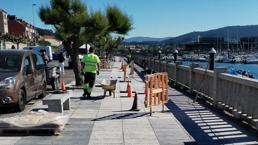 Obreros realizan trabajos de acondicionamiento en el paseo marítimo de Combarro, en Poio.  | // FDV