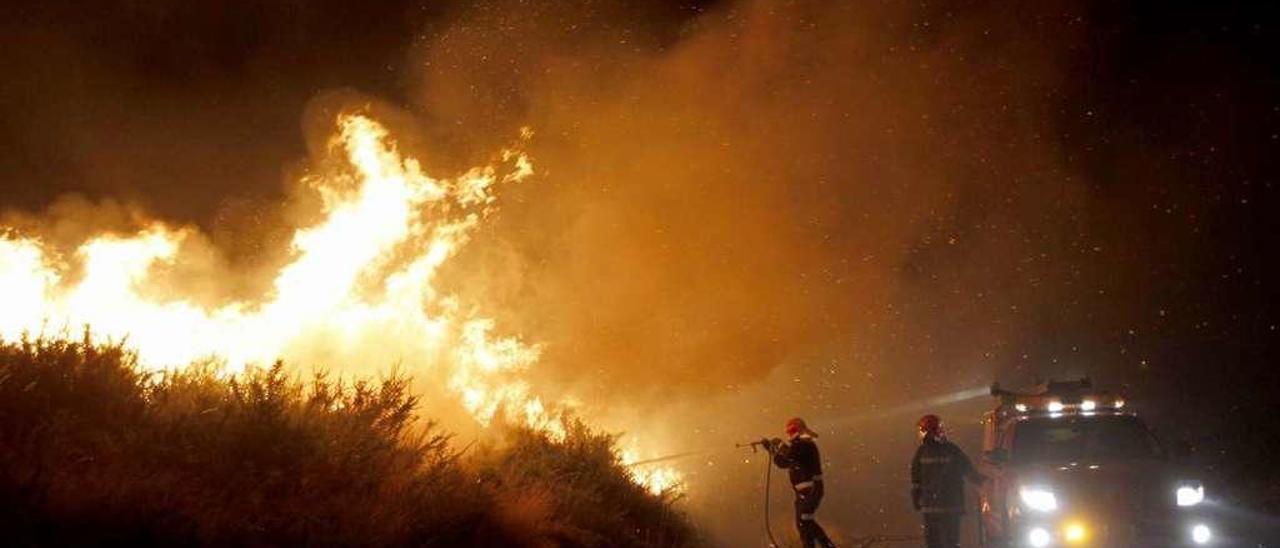 Dos brigadistas, apagando el incendio de Fornelos tras la muerte de los dos brigadistas. // José Lores