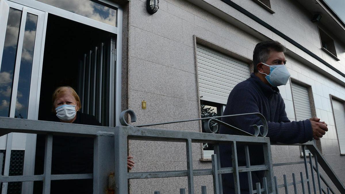 El vecino, junto a su madre, en la entrada de su casa el jueves tras el registro.