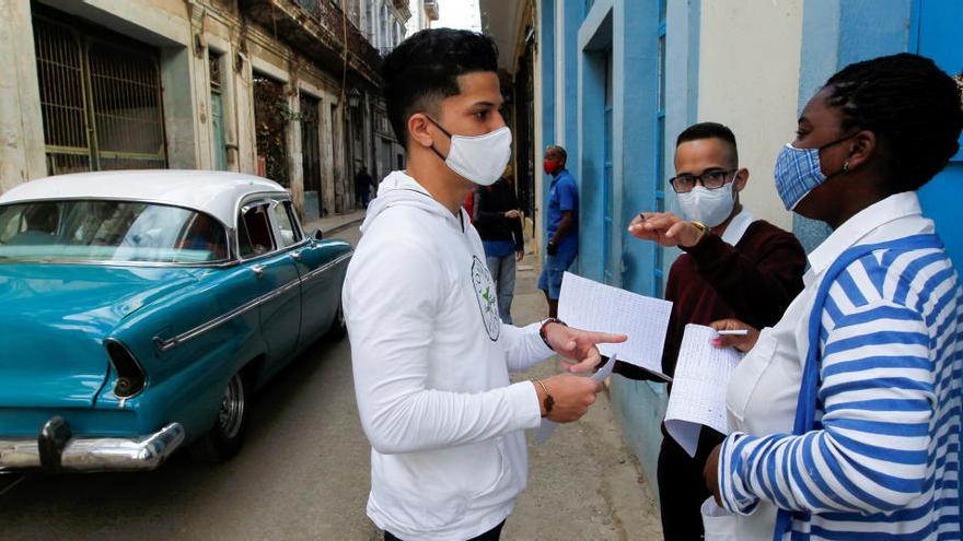 Estudiantes de medicina comprueban en La Habana si los residentes tienen síntomas de coronavirus.