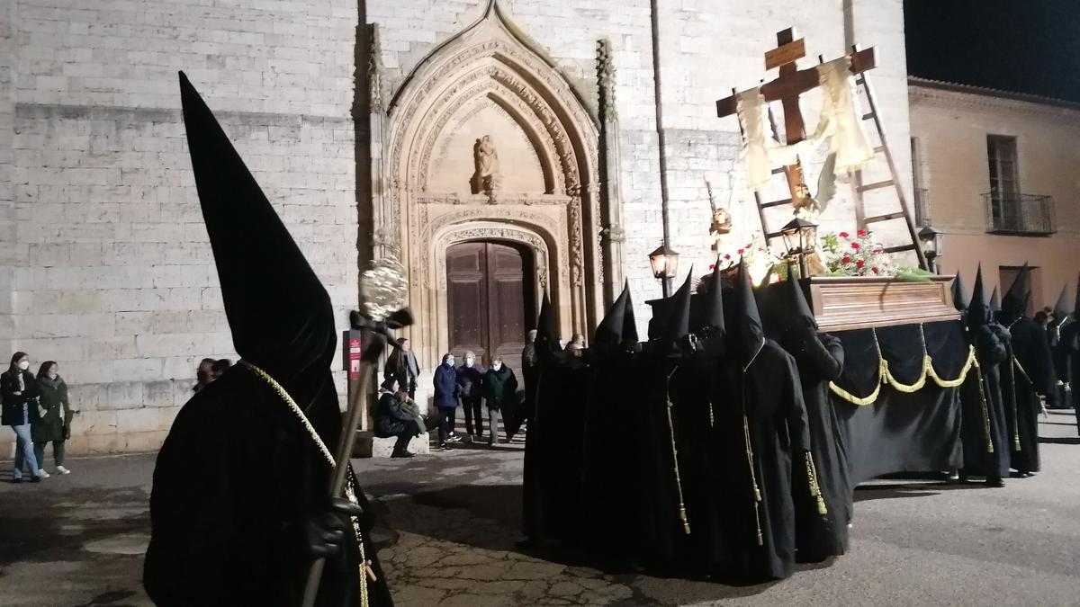 Los cargadores portan a hombros la cruz con sudario a su paso por la iglesia de San Julián