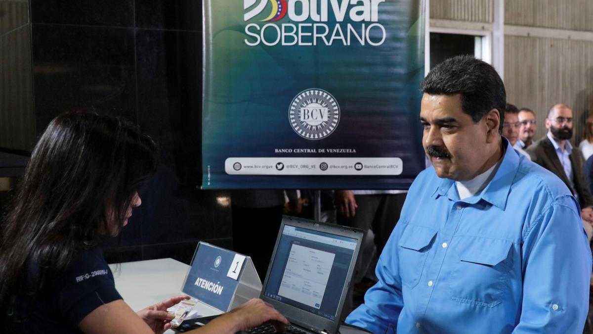 Venezuela's President Nicolas Maduro participates in the process to buy a savings certificate in gold at Venezuela's Central Bank in Caracas