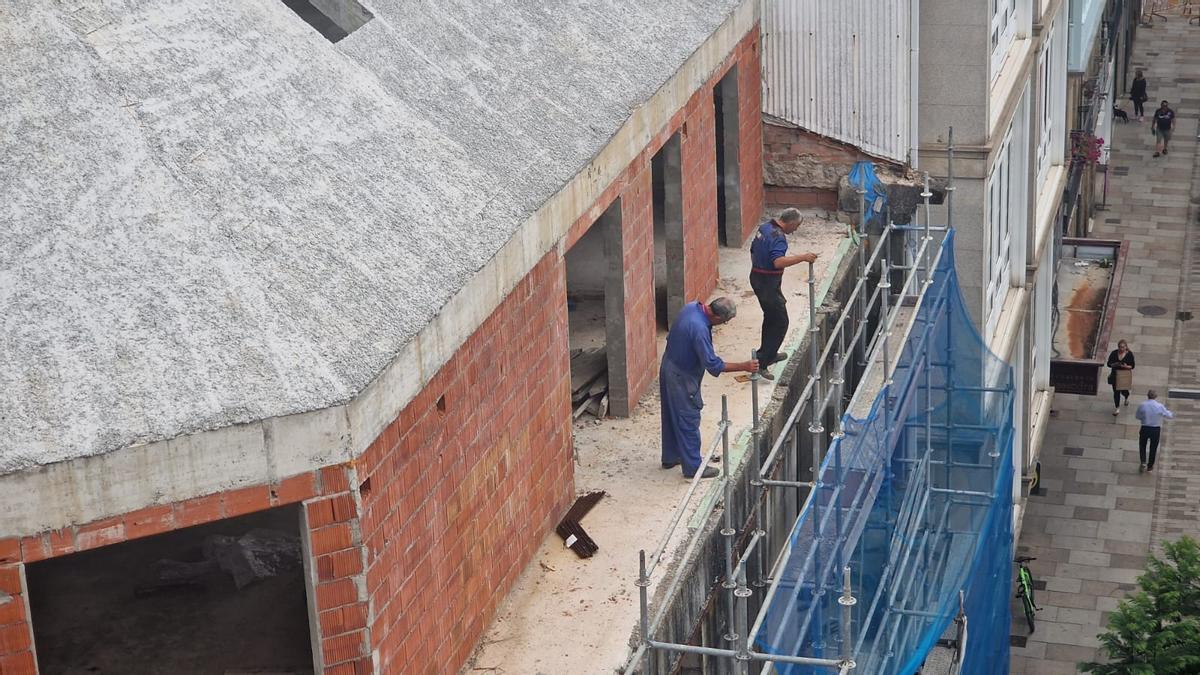 Dos de los trabajadores en el edificio, ayer.