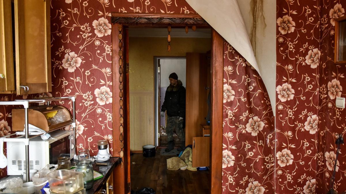 Un soldado inspeccionando una casa en ruinas tras ser bombardeada.