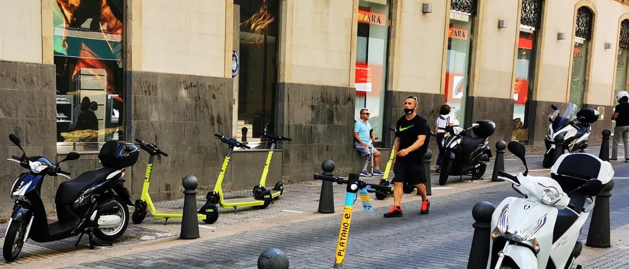 Patinetes de diferentes empresas aparcados en una céntrica calle de Santa Cruz.