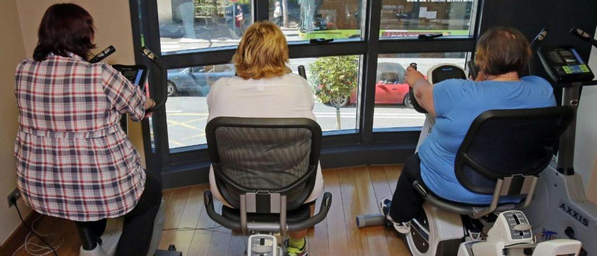 Personas con sobrepeso de Vigo realizan ejercicio en bicicletas estáticas.