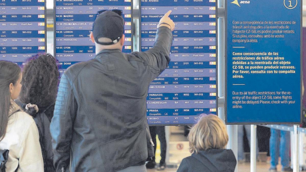 Una família comprova la sortida amb retard del seu vol ahir a l’aeroport del Prat. | FERRAN NADEU