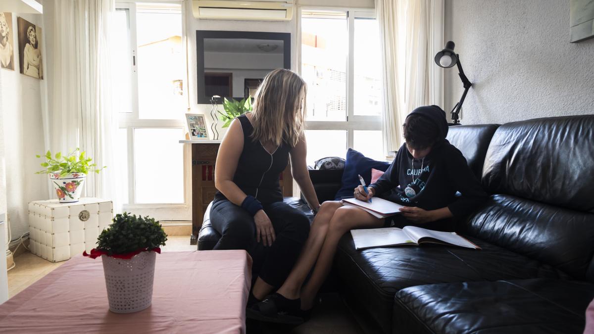 Valencia. Una familia beneficiaria del bono social de la luz realiza los deberes junto a una ventana para ahorrar luz