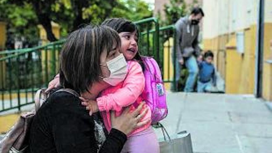 Una niña se abraza a su madre antes de entrar. | Emilio Fraile