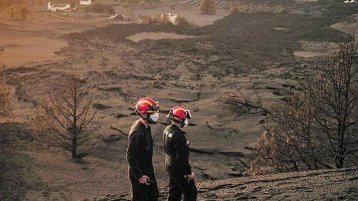 Dos profesionales de la UME inspeccionan la zona próxima al volcán. / ANDRÉS GUTIÉRREZ