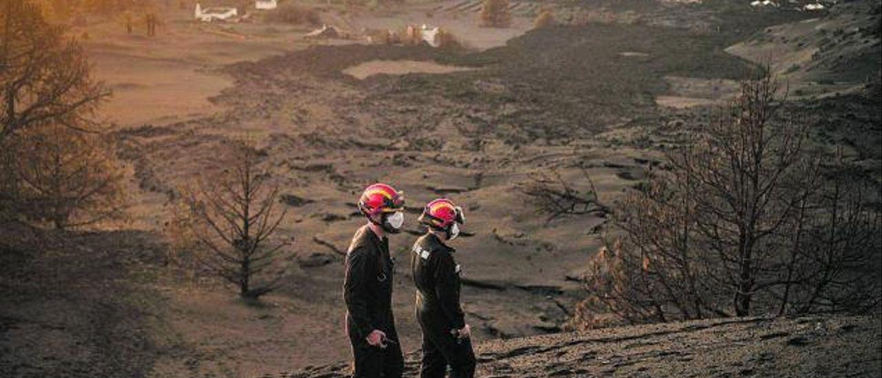 Dos profesionales de la UME inspeccionan la zona próxima al volcán. / ANDRÉS GUTIÉRREZ