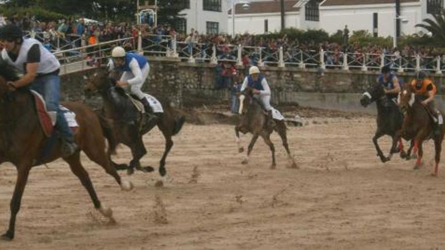 Los competidores, durante la disputa de la primera categoría de la prueba, con el paseo de la playa de Santa Marina abarrotado de público.