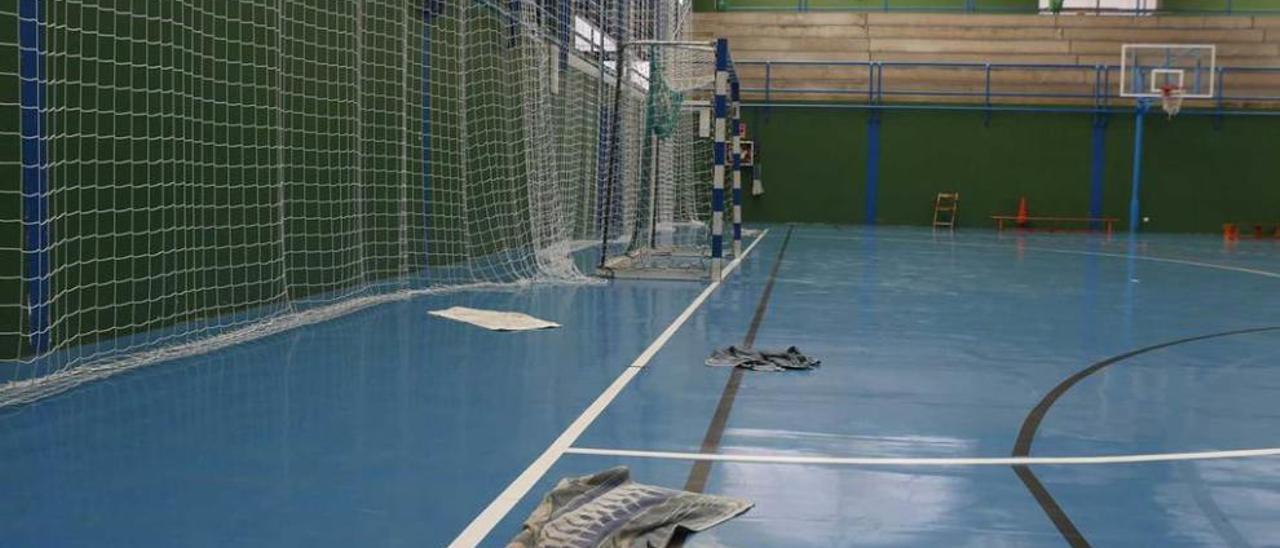 Toallas tiradas en el polideportivo de Luanco en zonas con goteras.