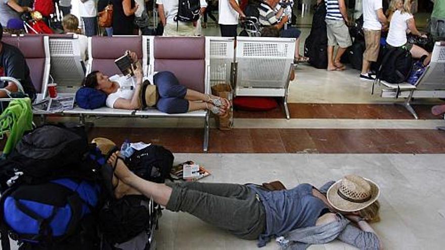 Un pasajera duerme, en una imagen de ayer, en el suelo de la terminal de El Altet en espera de recibir información de su vuelo, retrasado por las bajas de los controladores.