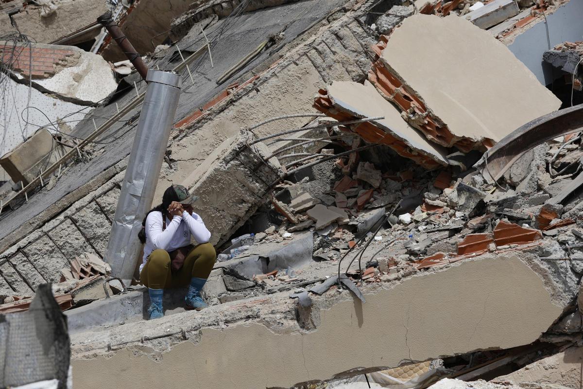 Una mujer se sienta sobre los escombros de un edificio derrumbado en Caraballeda, estado de La Guaira, Venezuela