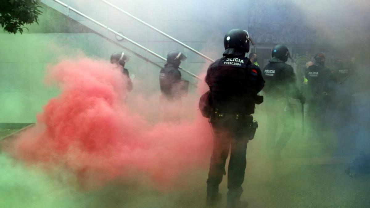 Un agents dels Mossos entre pots de fum de colors  | ÀLEX RECOLONS/ACN