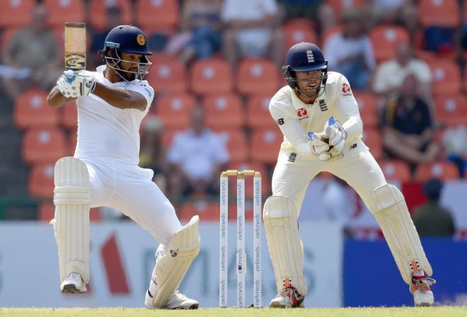 Dimuth Karunaratne (L), de Sri Lanka, juega un tiro mientras el portero de Inglaterra Ben Foakes (R) observa durante el segundo partido de entrenamiento entre Sri Lanka e Inglaterra en el Pallekele International Cricket Stadium en Kandy.