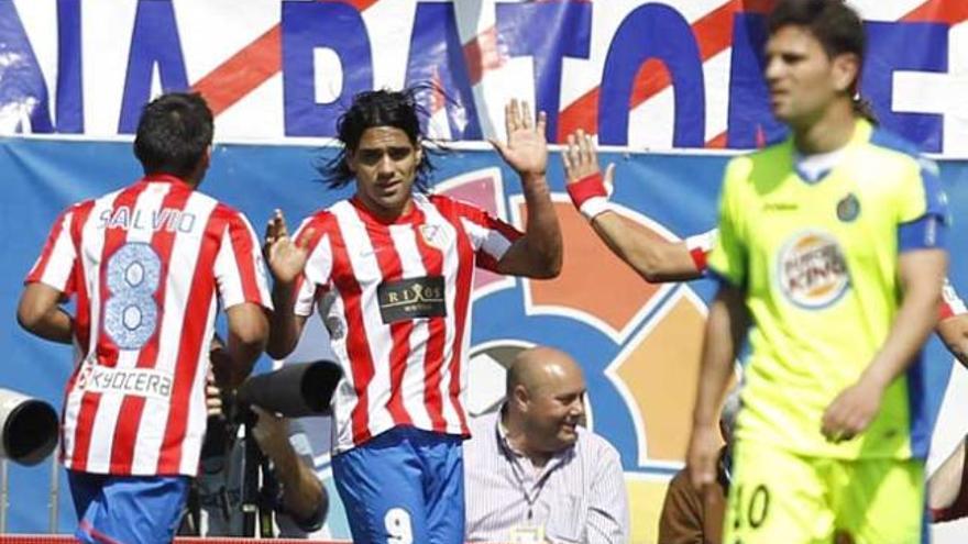 El delantero colombiano del Atlético de Madrid Radamel Falcao (c) celebra con su compañero Eduardo Salvio el tercer gol que marcó al Getafe.