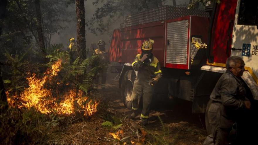Varios operarios intentan apagar las llamas de uno de los incendios de Ourense. |   // BRAIS LORENZO