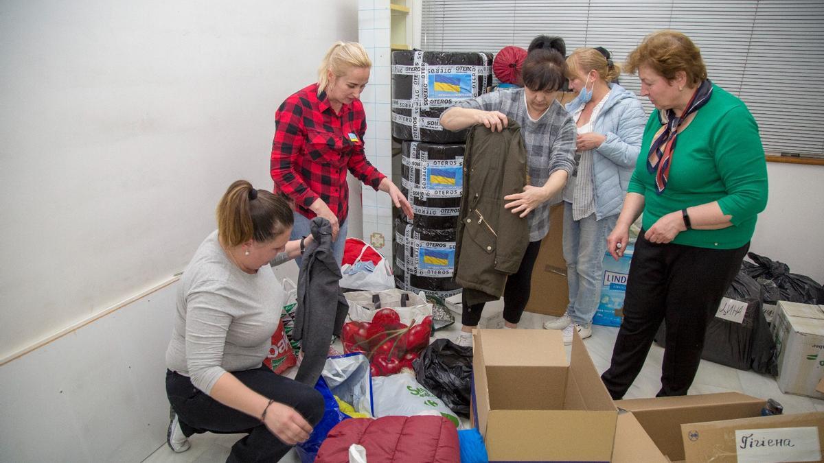 Voluntarias ucranianas clasifican la ropa donada por los cordobeses.