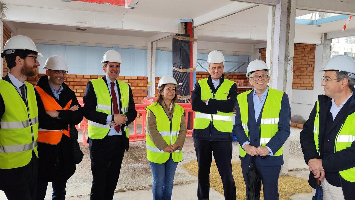 La conselleira Marta Villaverde, con Botana y representantes de la comunidad portuaria, en la futura nave de rederas, en obras.