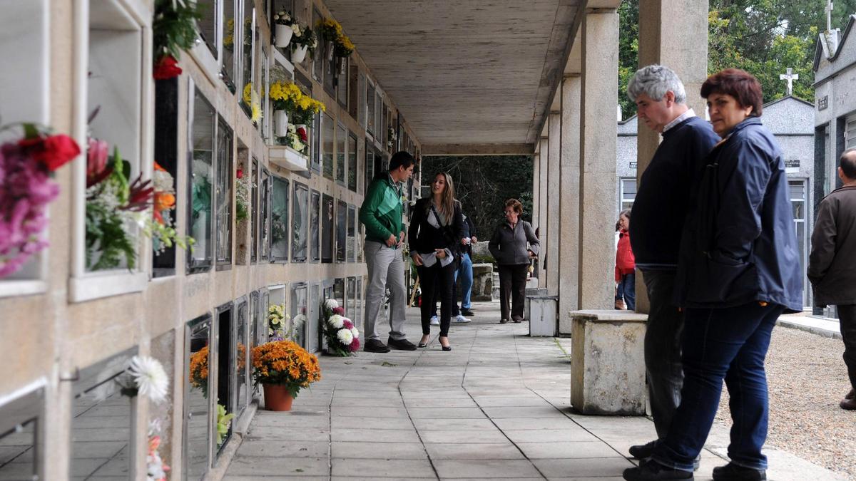 Visitantes llevando flores al cementerio.