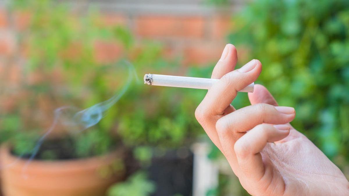 Imagen de una persona fumando en el exterior.