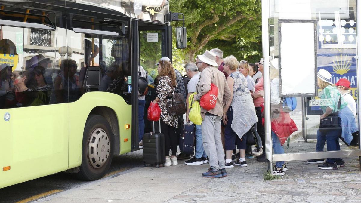 Un nutrido grupo de turistas tratando de subir al bus para ir al aeropuerto este domingo / antonio hernández