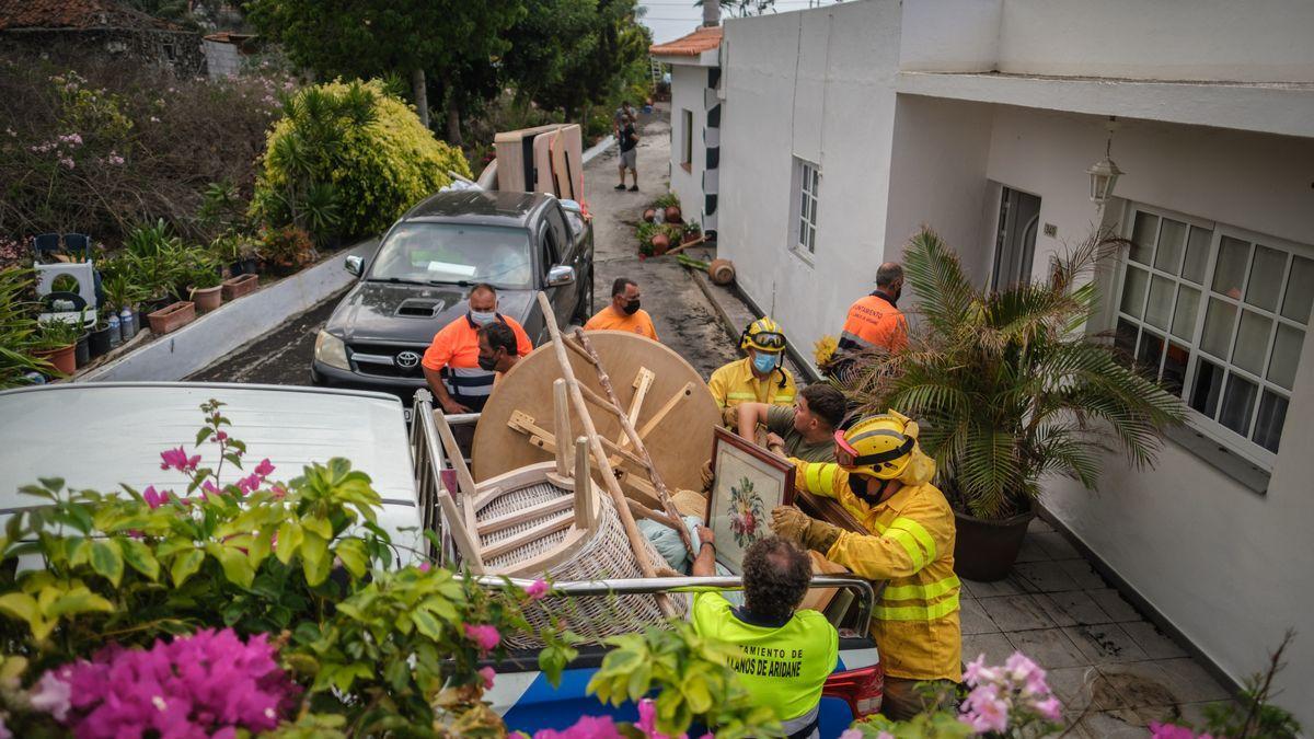 Bomberos y personal del Ayuntamiento ayudan a las familias a sacar enseres de sus casas.