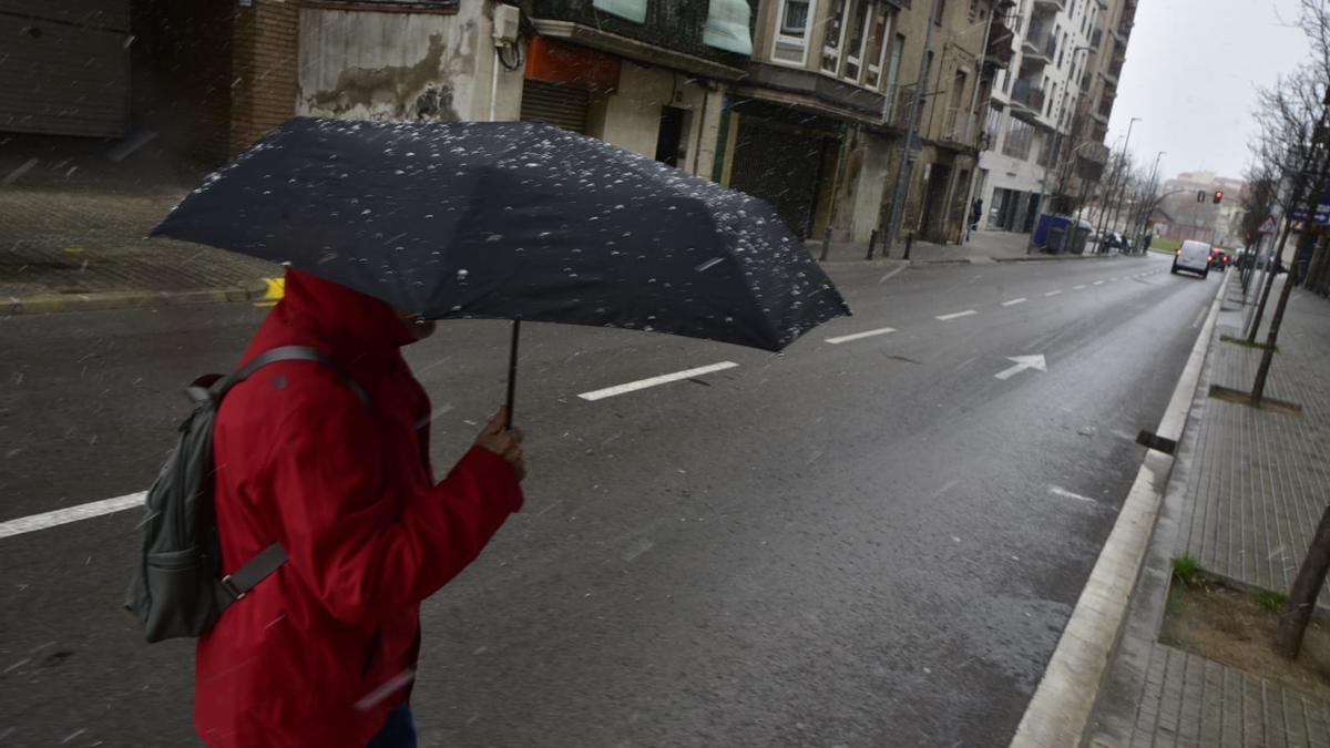 Una persona camina amb paraigües a Manresa per protegir-se de la neu
